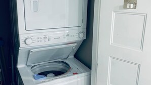 Een wasmachine en droger met voorlaadopening, voorzien van een bedieningspaneel en een deur met lichtschakelaar.
