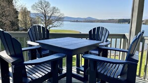 A deck with a table and four Adirondack chairs facing a lake with mountains in the background. - Amazing View, Quiet Cove of Bernards Landing, Sandy Beach, 3 Kings and Twin Bunk (Moneta)