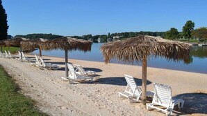 A beach with white lounge chairs and thatched umbrellas aligned along the shore. - Amazing View, Quiet Cove of Bernards Landing, Sandy Beach, 3 Kings and Twin Bunk (Moneta)
