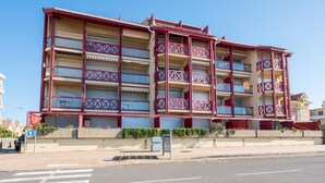 A multi-story hotel with balconies, a pedestrian walkway, and a clear sky. - Primavéra by Interhome (Lacanau)