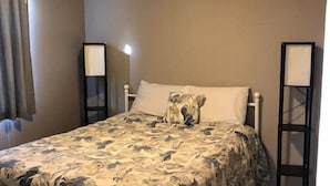 Une chambre à coucher avec un lit, un ventilateur de plafond et des lampes de chevet.