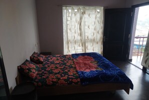 Simple bedroom with a single bed and a window with a sheer curtain.