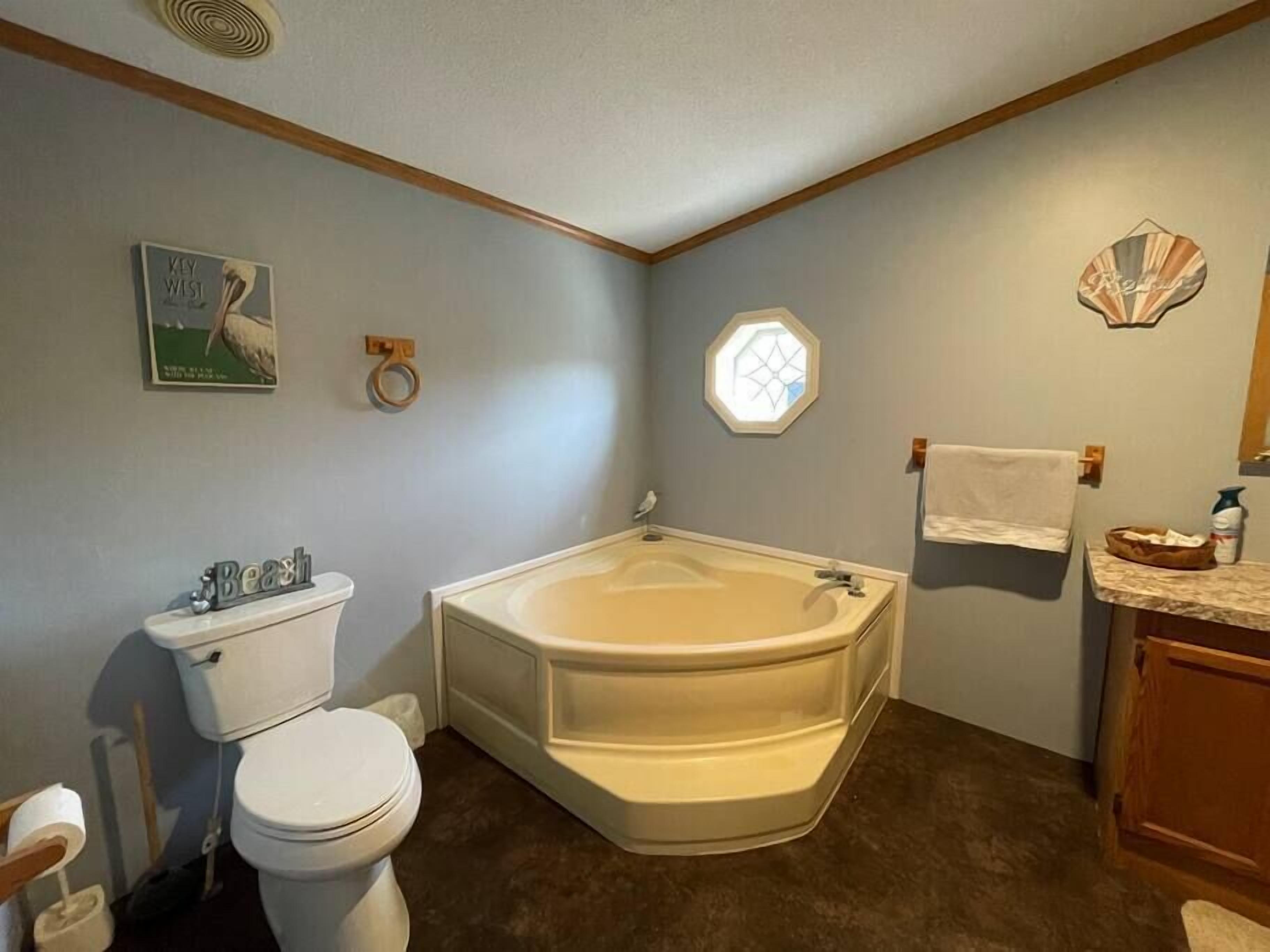 Une salle de bain comprenant des toilettes, une baignoire et un lavabo.