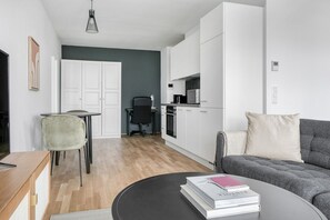 A modern living space with a dining area, kitchenette, and seating area.