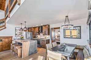 A spacious kitchen with wooden cabinets, a central island, and pendant lighting. - Indoor/Outdoor Fireplace, Jacuzzi, Heated Bathroom Floors (Estes Park)
