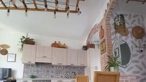 Una cocina moderna con armarios de madera clara, salpicadero de azulejos y una isla central.
