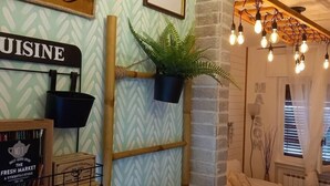 Una sala de estar acogedora con un muro de diseño espiga, una planta colgante, una mesa de centro y un aplique.