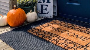 A house with a blue door, a welcome sign, and a doormat. - Des Moines River Front Cabin- Fishing/Hunting/Kayaking (Keosauqua)