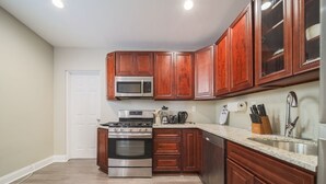 Una cocina con armarios de madera, electrodomésticos de acero inoxidable y encimera de granito.