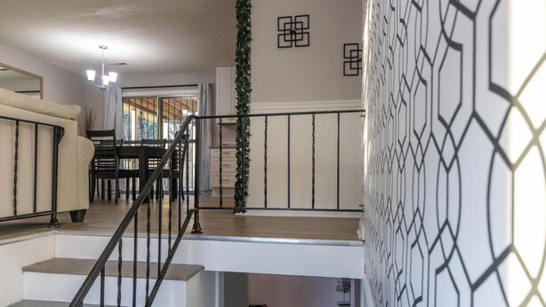 A staircase with a black railing leading to a second-floor landing.
