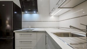 A modern kitchen with white cabinetry, stainless steel appliances, and a sleek design. - Studio with charm at the historic center. WIFI/AC (Sevilla)