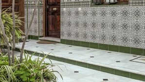 A tiled hallway with a patterned wall and a wooden door. - Studio with charm at the historic center. WIFI/AC (Sevilla)