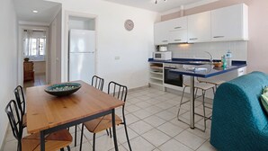 A compact kitchen with white cabinets, a microwave, and a sink.