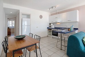 A compact kitchen with white cabinets, a microwave, and a sink.
