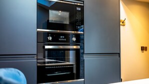 A modern kitchen with a built-in oven and microwave, stainless steel appliances, and a clean, minimalist design.
