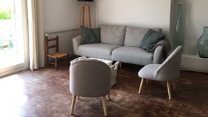 A living room with a grey sofa, two armchairs, a floor lamp, and a radiator. - Charming renovated sheepfold in a natural setting, not overlooked, private swimming pool (La penne sur l'ouveze)
