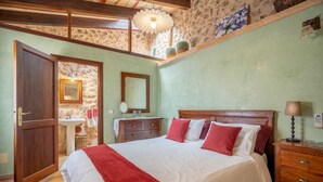 A bedroom with a bed, wooden headboard, bedside table, and a nightstand. - Country Home "Can Pulit" with Pool, Garden, A/C & Wi-Fi (Selva)