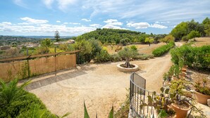 A garden with a gravel path, various plants, and a wooden fence. - Country Home "Can Pulit" with Pool, Garden, A/C & Wi-Fi (Selva)