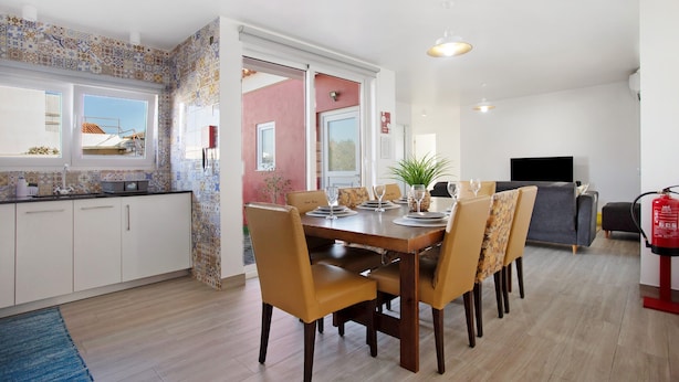 Un comedor con una mesa y sillas de madera, un televisor y un extintor.