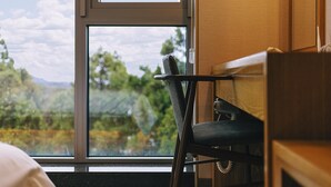 Ein Zimmer mit Blick auf eine gebirgige Landschaft durch ein großes Fenster.
