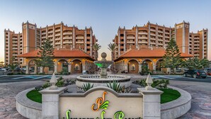 L'ingresso del Jonoran Sun Resort, con una fontana centrale, circondato da un giardino curato e due edifici con tetti in tegole rosse.
