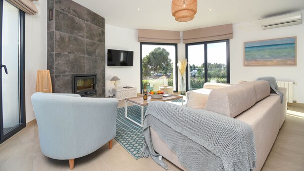 A modern living room with a sofa, armchair, and a fireplace. - Modern and nice villa  with private pool in Benissa, Costa Blanca, Spain for 6 persons (Benissa)