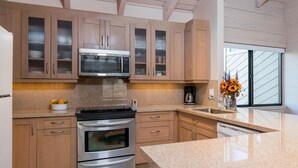 A modern kitchen with stainless steel appliances, wooden cabinets, and a granite countertop. - Snowcreek 1571 (Sun Valley)