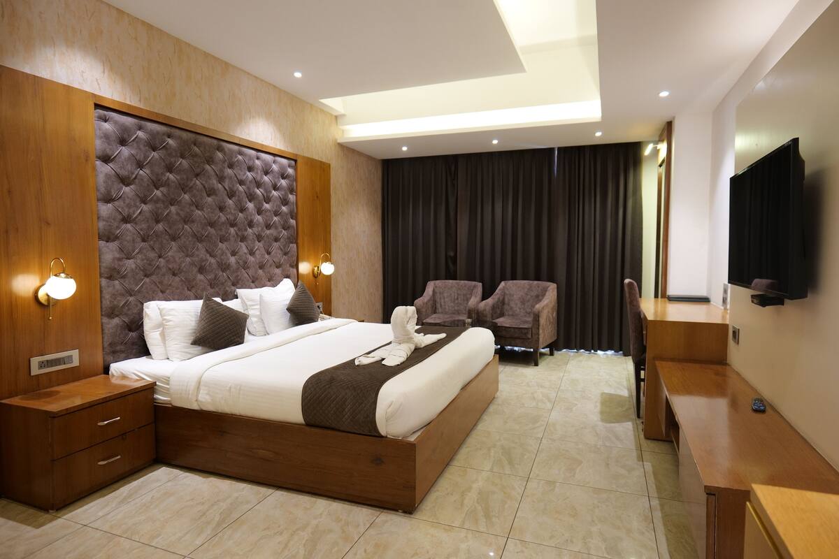 Habitación Deluxe, 1 cama de matrimonio grande, balcón, vistas a la piscina | 1 dormitorio, caja fuerte, escritorio y tabla de planchar con plancha