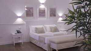 A bedroom with a bed, bedside tables, and wall-mounted lights. - Palazzo Sant'Elena (Foggia)