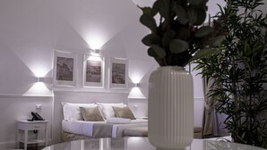 A bedroom with a bed, bedside lamps, a nightstand, and a vase with flowers. - Palazzo Sant'Elena (Foggia)