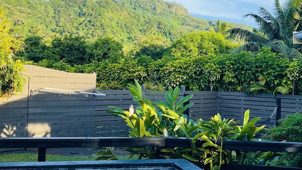 Una piscina con vistas a verdes colinas y un cielo azul despejado.