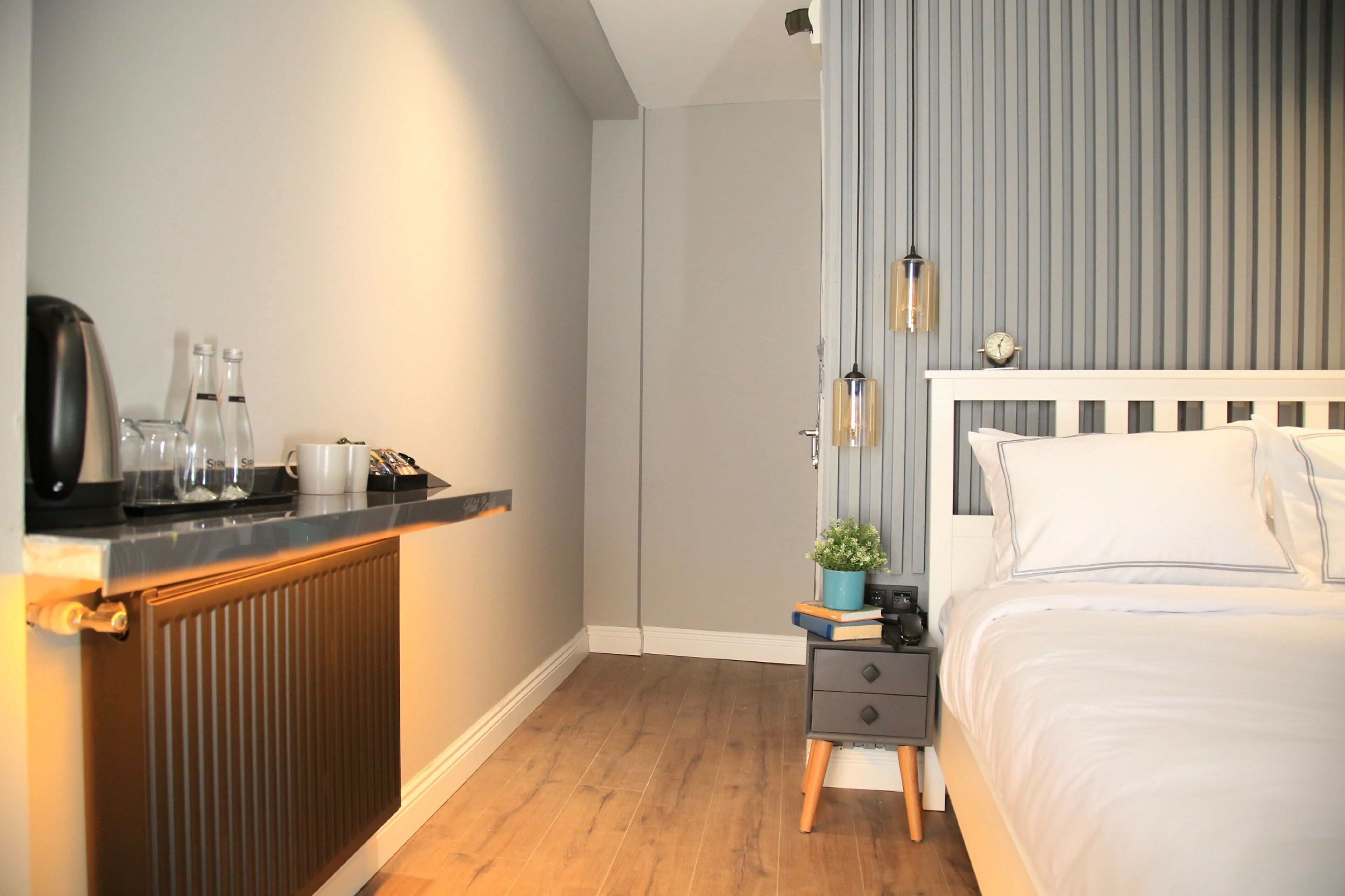 Un dormitorio moderno con cama, mesita de noche y radiador.