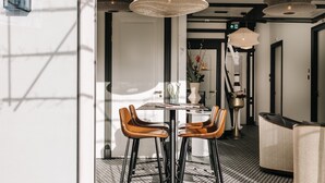 A modern interior with a dining area featuring two leather chairs, a table, and a decorative vase. - Boutique hotel Margretha (Zandvoort)