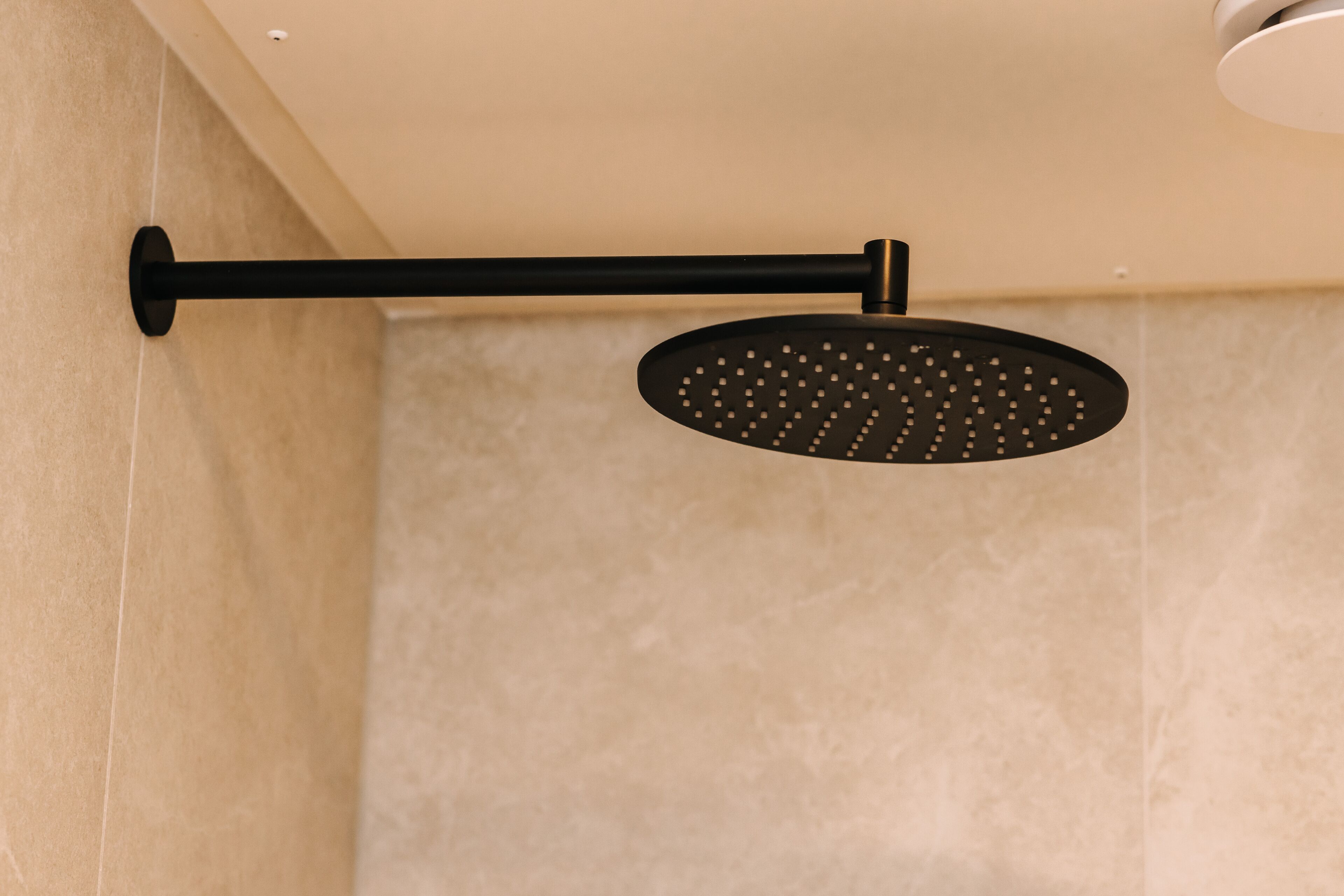 A showerhead mounted on a wall with a horizontal bar.