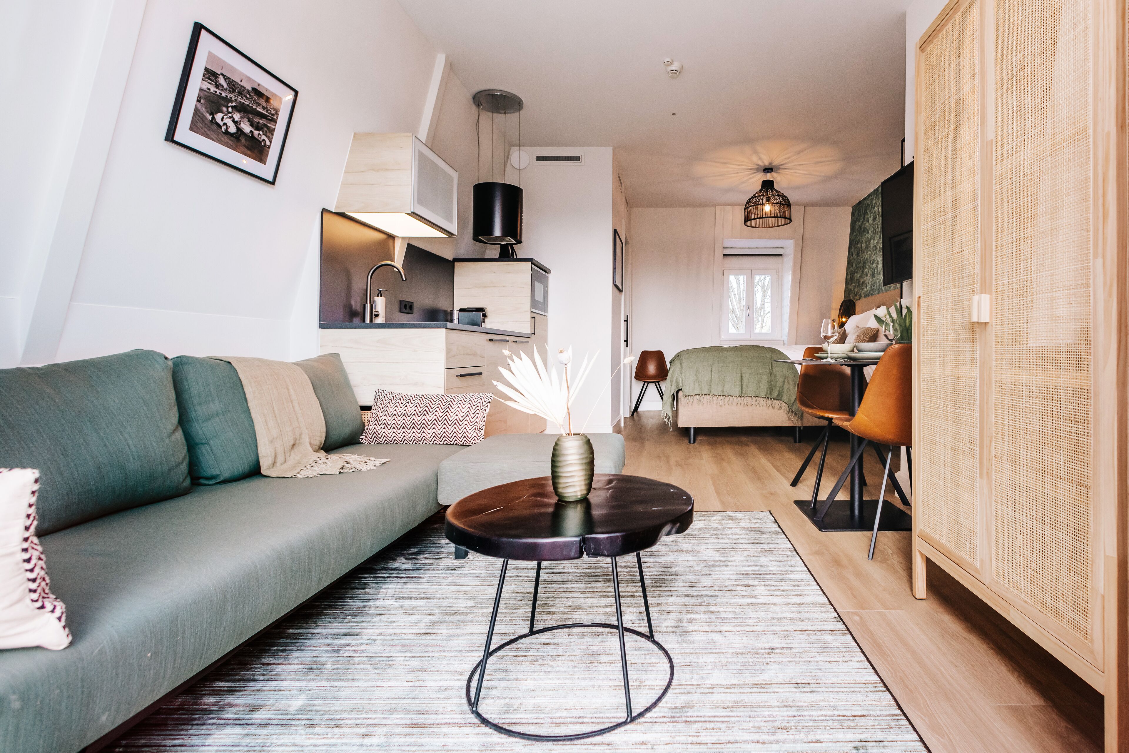 Un salon moderne comprenant un canapé, une table basse et un coin repas avec des chaises.