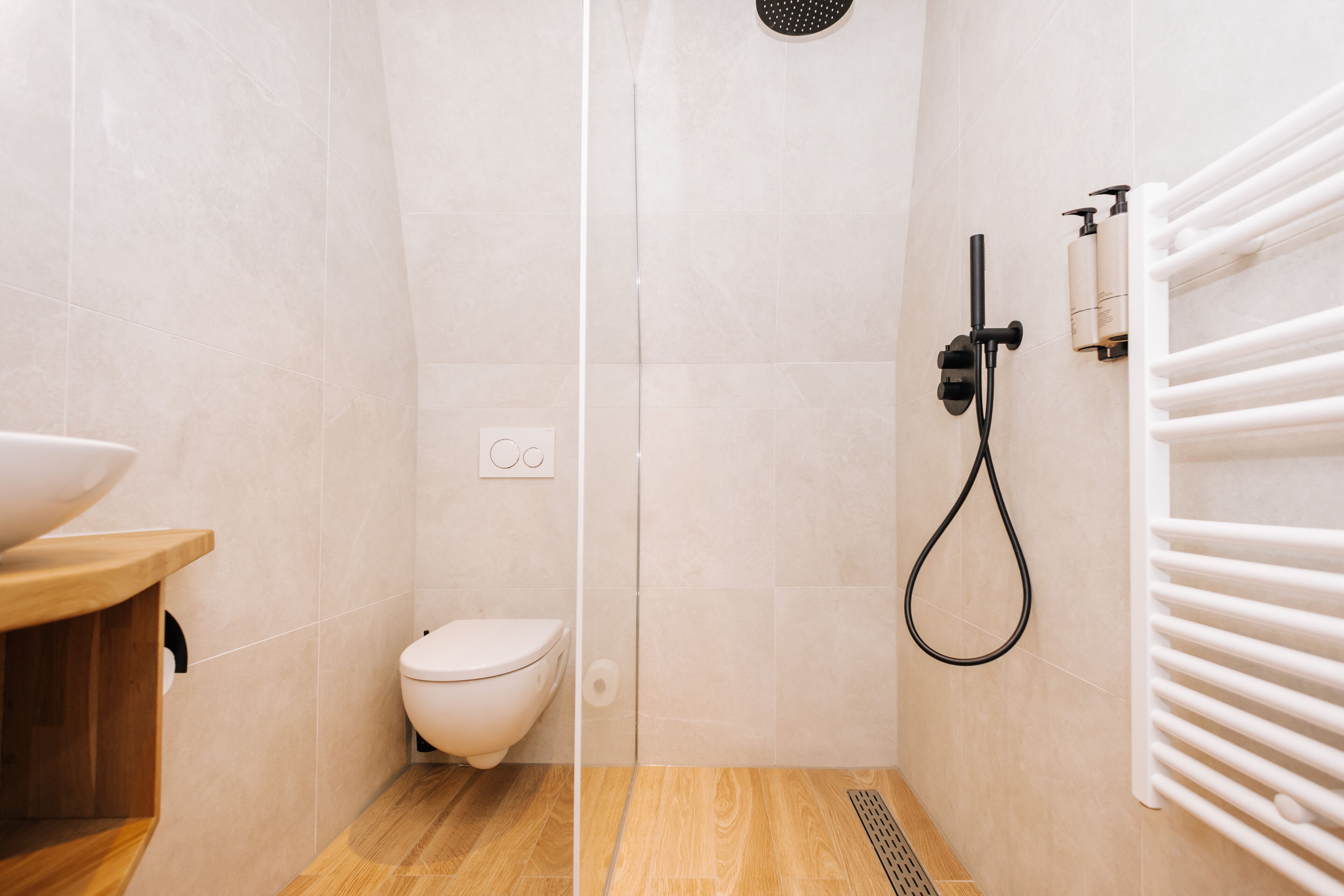 Un baño moderno con inodoro, ducha y tocador de madera.