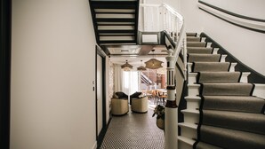 A staircase with a geometric patterned carpet and a white railing. - Boutique hotel Margretha (Zandvoort)