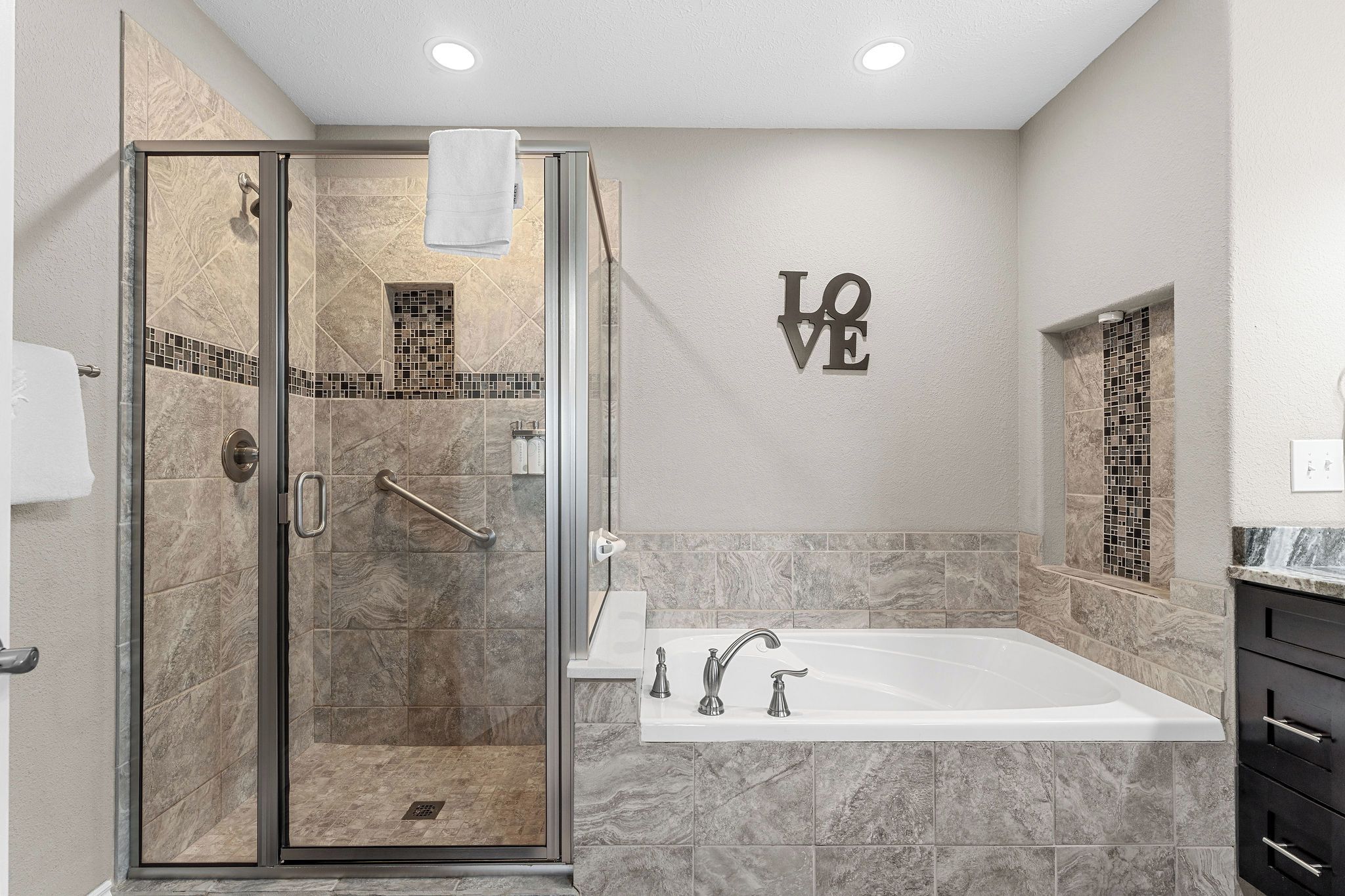 A modern bathroom with a glass shower enclosure, a freestanding bathtub, and a wall-mounted vanity.