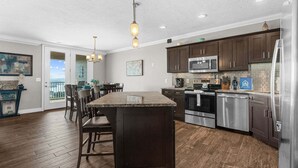 A modern kitchen with dark wood cabinets, stainless steel appliances, and a central island. - Luxury Condo with Lake Views, Free WiFi & Minutes from Silver Dollar City (Branson)