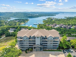 Un hôtel à plusieurs étages doté d’une cour intérieure, entouré d’une végétation luxuriante et bordé d’un lac où l’on peut faire du bateau.