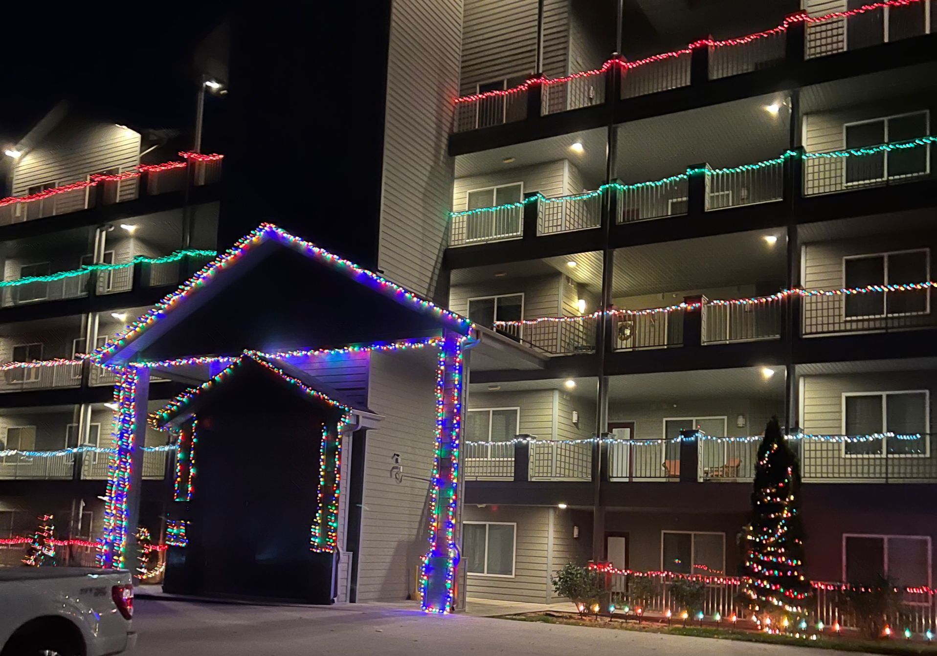 Um edifício com vários andares e varandas decoradas com luzes coloridas.