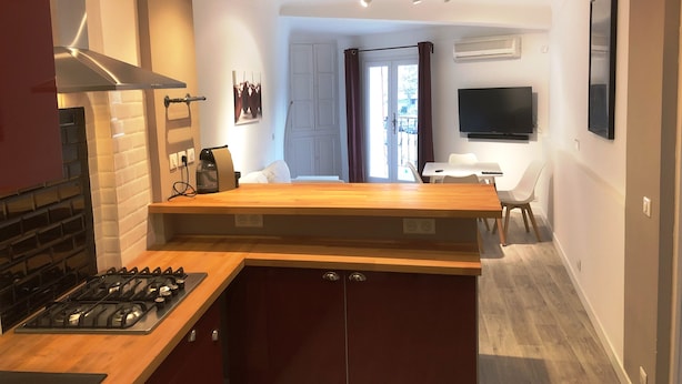 Una cucina moderna con isola centrale, piano cottura integrato e zona pranzo con tavolo e sedie.