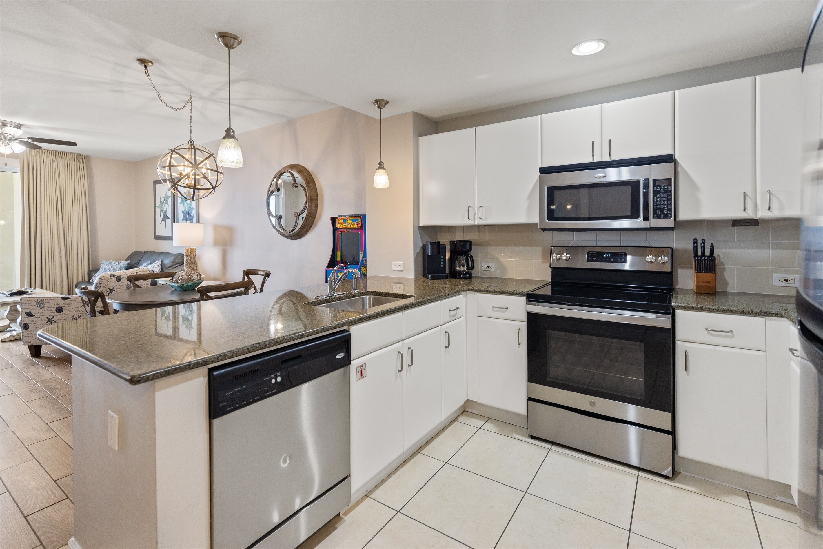 A modern kitchen with white cabinets, stainless steel appliances, and a granite countertop.