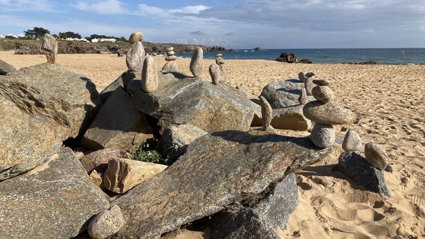 Una playa con grandes rocas y cielo despejado.