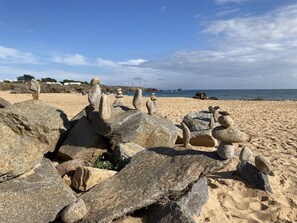 Una spiaggia con grosse rocce e cielo sereno.