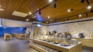 Montaje de bufé con múltiples estaciones de servicio, una pared de ladrillo y detalles de techo de madera.