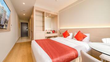 Une chambre d’hôtel moderne avec un grand lit, un bureau et un dressing.