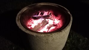 Ein Beton-Feuerkorb mit glühenden Glutresten.