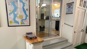 A room with a map on the wall, a small table with a book, and a trash can. - Charming 1930's house only a few blocks from the St. Johns River! (Welaka)