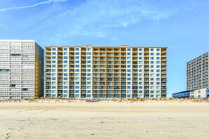 Un hôtel à plusieurs étages, doté d’une façade uniforme, de balcons et d’une cour intérieure.